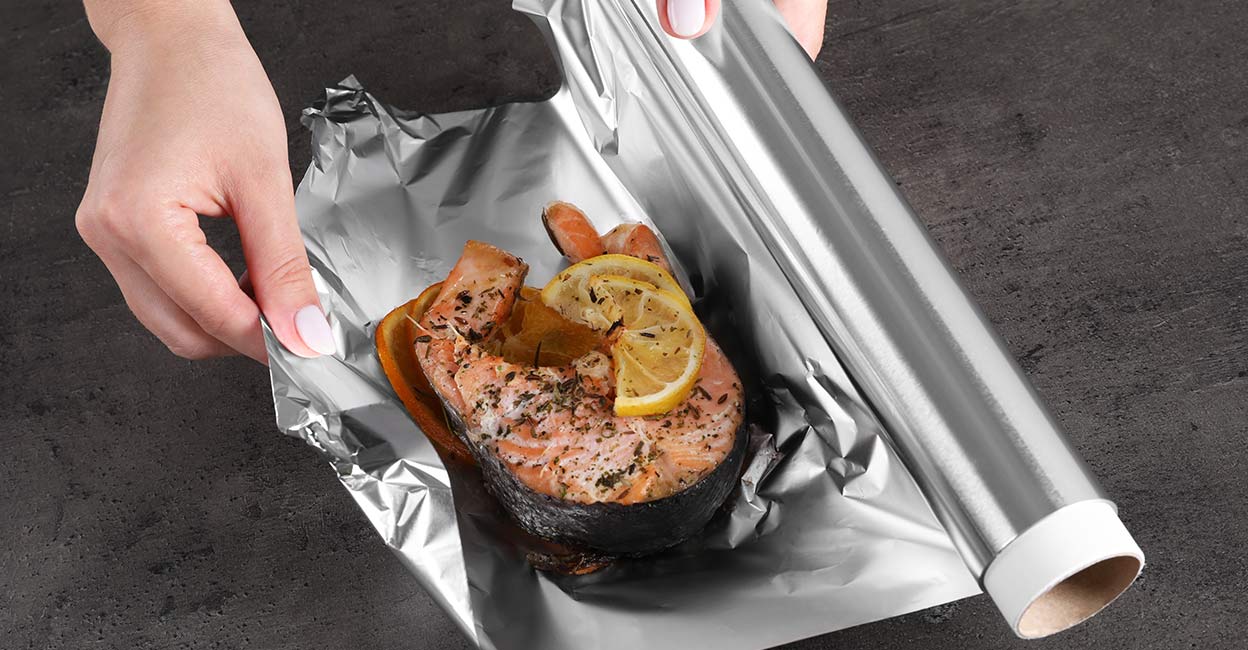 Aluminium foil Wrapping salmon with lemon and spices in aluminum foil. Photo: Shutterstock/New Africa