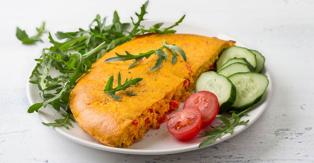 Vegan chickpea omelet with bell peppers Vegan chickpea omelet with bell peppers served with tomatoes, cucumbers, lettuce and parsley. Photo: iStock/OlgaLepeshkina