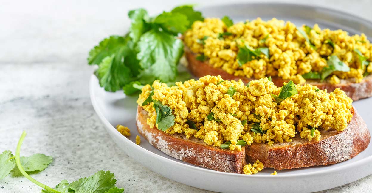 Vegan scrambled egg Tofu scramble with greens toast on a gray plate. Photo: iStock/vaaseenaa