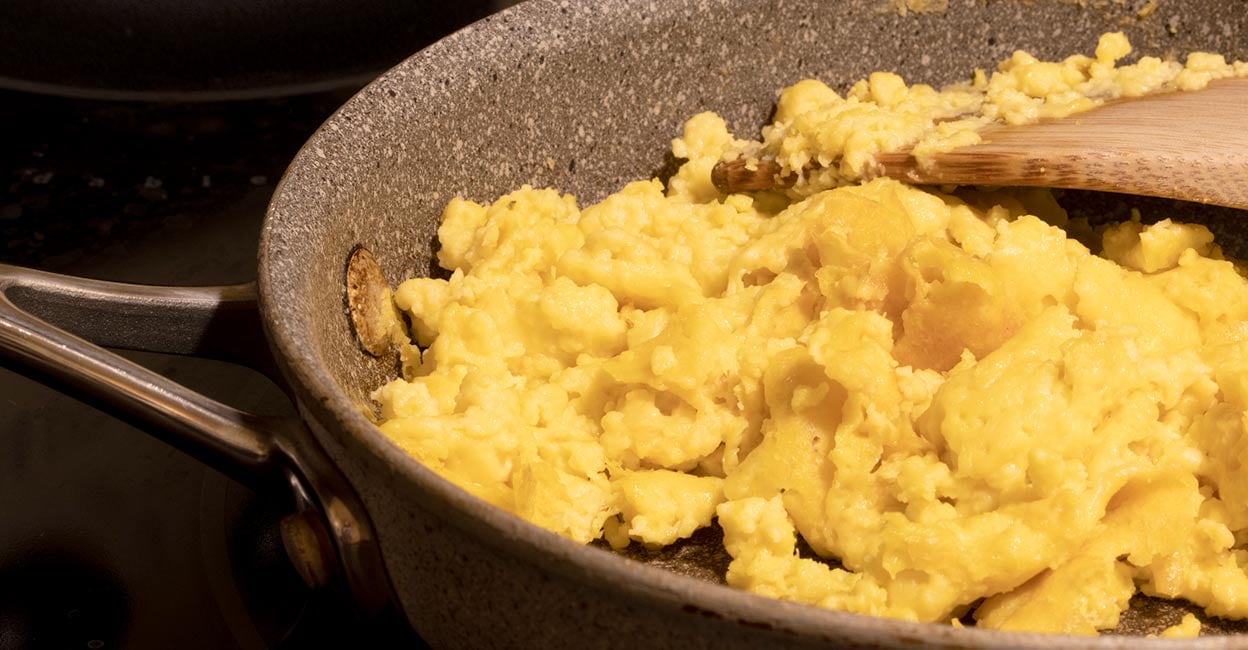 Vegan egg scramble Closeup of scrambled eggs made with plant-based egg scramble mixture alternative in a skillet on an electric stove. Photo: iStock/hapabapa