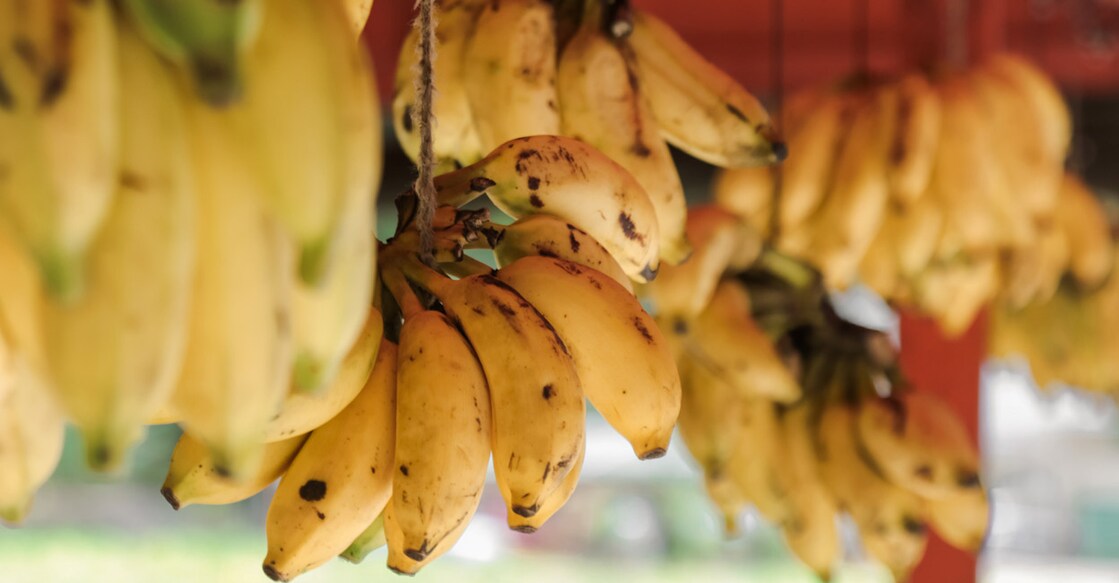 Bananas hanging at a market stall. Photo: iStock/MelanieMaya