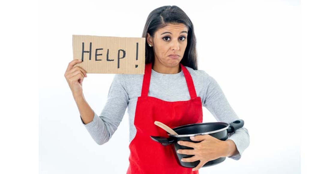 Portrait of desperate helpless inexperienced home cook woman asking for help wearing red apron learning to cook in cooking classes isolated on white background.