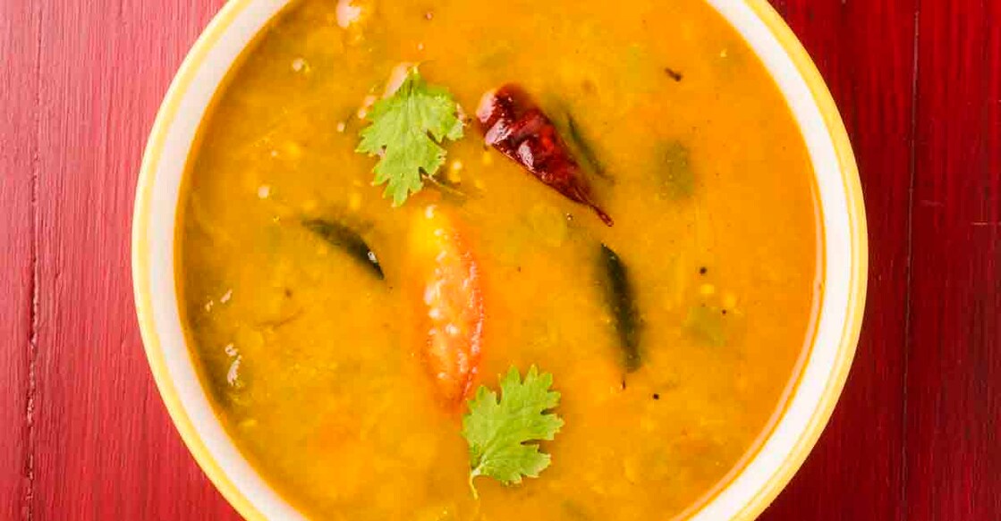 south indian vegetable sambar isolated on red wooden background