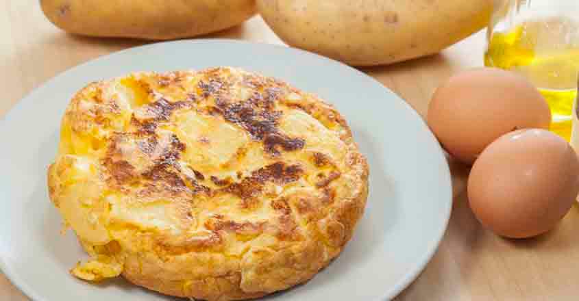 585785666 Tortilla de patatas with the main ingredients, eggs, potatoes, olive oil and salt.