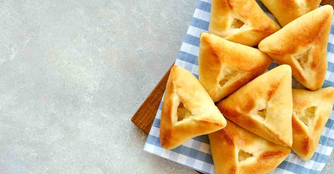 Fatayer, samosa with white cheese on wooden board. Top view with space for text
