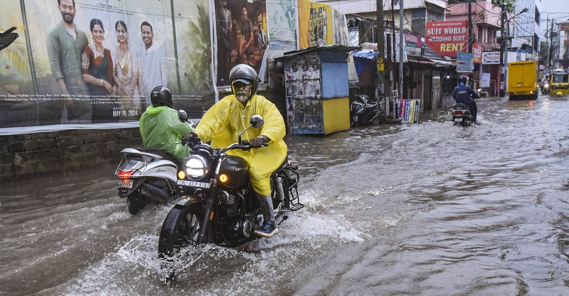 Commuters wade through a flooded road amid rains, in Kochi, Wednesday, May 29, 2024. Photo: PTI