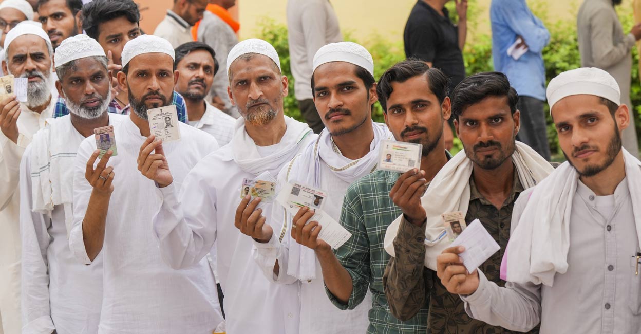 Voters wait in a queue at a polling booth to cast votes during the seventh and last phase of Lok Sabha elections, in Varanasi, Saturday, June 1, 2024. Photo: PTI.