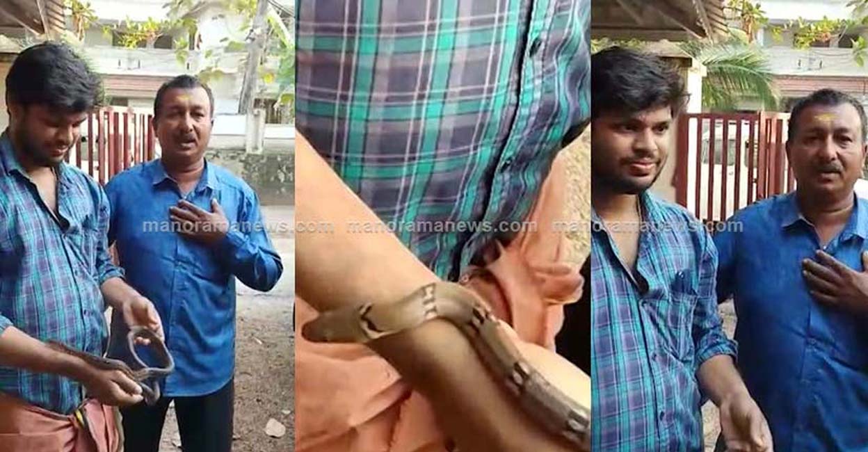 Chavarukavu Suresh (R) is seen handing over a snake  to Sooraj (L)