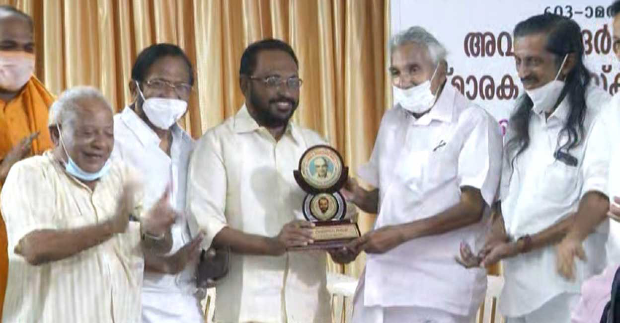 Cherian Philip receiving the Avukaderkutty Naha Award from Oommen Chandy.