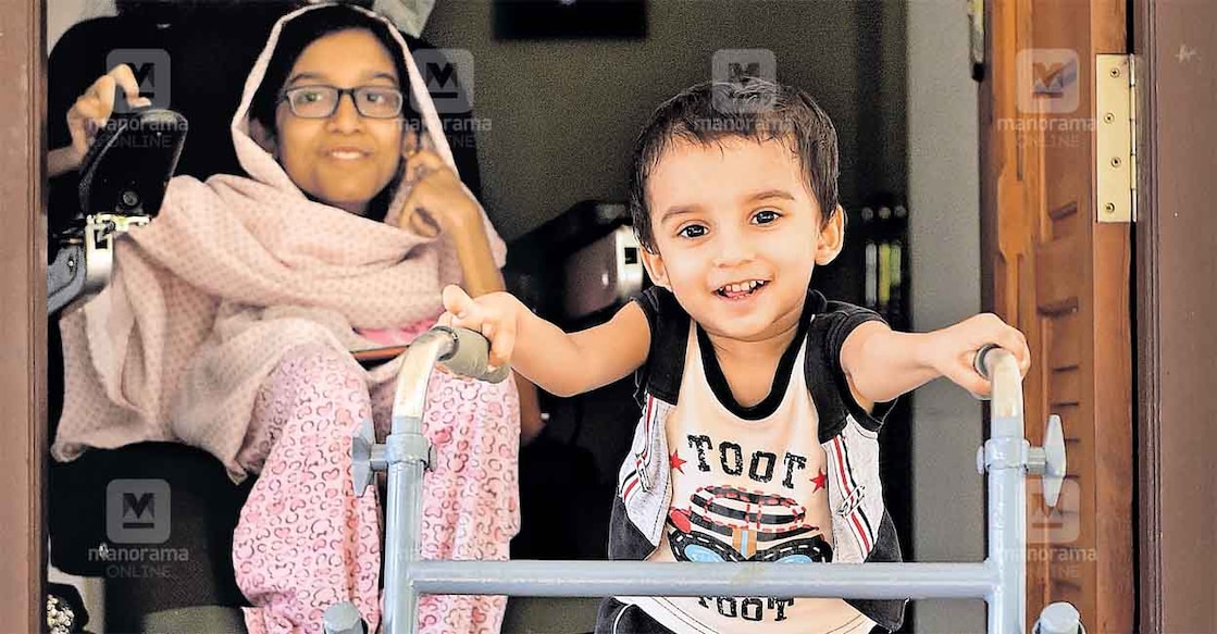 Mohammed, who suffers from Spinal Muscular Atrophy, takes his first steps with the help of a walker at his home in Mattool, Kannur. His sister Afra can be seen besides him. Photo: Manorama