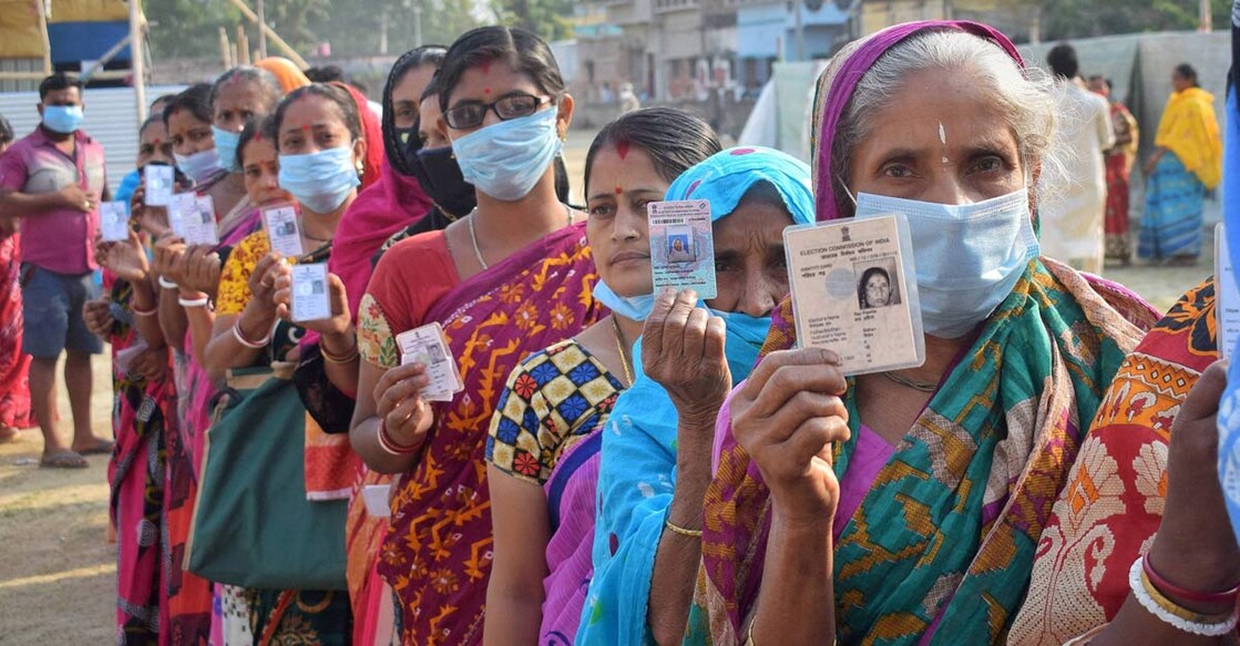 People stand in a queue to cast their vote at a polling station during the 5th phase of State Assembly elections at Santipur, in Nadia, Saturday, April 17, 2021. PTI