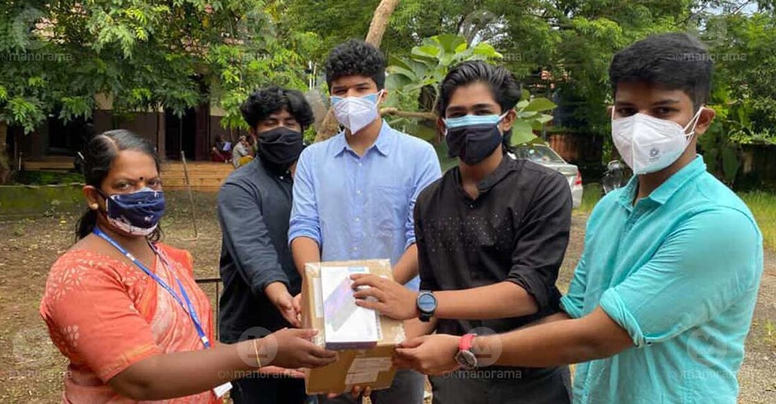 Students of Pallikoodam School handover Tablets to a teacher at government school in Kumarakom