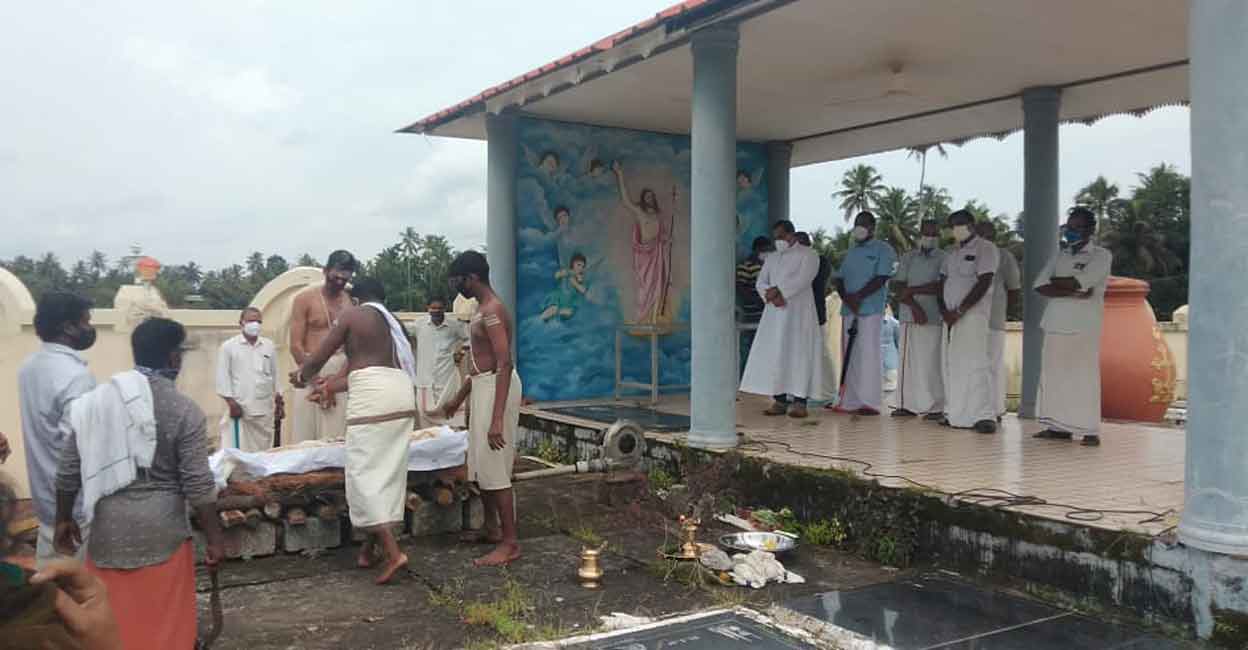 cremation Fr Varghese Mathilakathuzhy and parishioners witness the funeral of Omana inside the cemetery of St Joseph's Church, Ramankary on Thursday. Photo: Special Arrangement