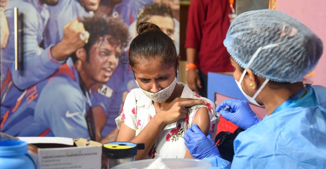 A healthcare worker inoculates a dose of Covid-19 vaccine to a beneficiary during a free vaccination camp at Shahaji Raje Sport Complex in Mumbai, Saturday, Aug. 28, 2021. PTI