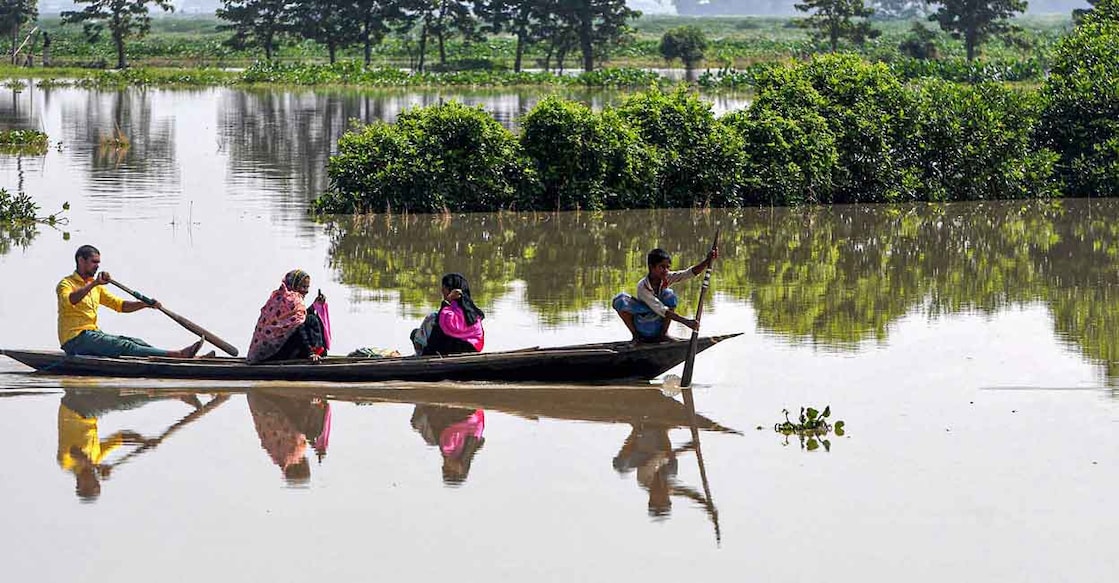 A family takes shelter on a boat during the flood in Assam. File Photo: PTI
