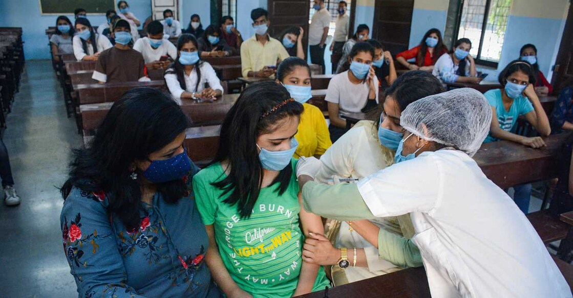 A Municipal Corporation worker administers a dose of COVID-19 vaccine to a teenager, at a municipal school in Thane, Monday, January 17, 2022. PTI