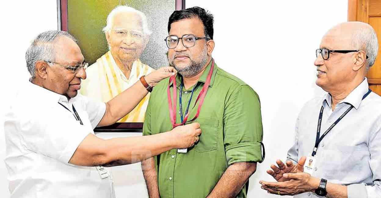 Manorama Chief Editor Mammen Mathew presents the award to Tony Jose. Editorial Director Mathews Varghese looks on. 