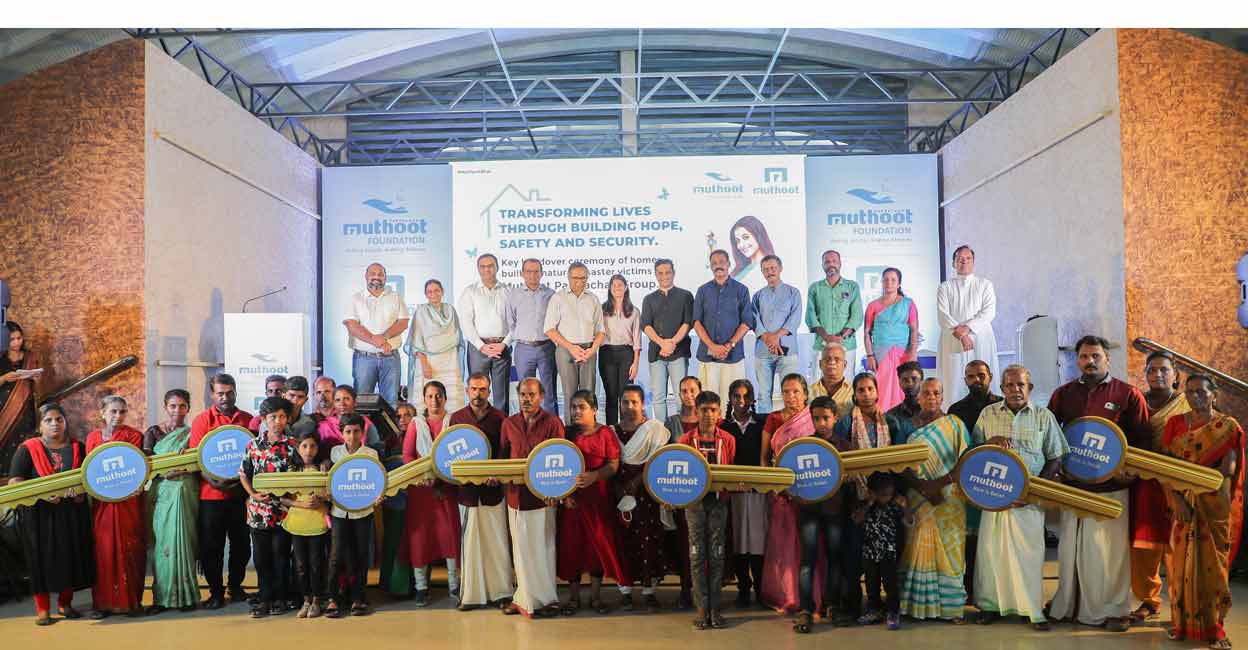 Beneficiaries of the  Muthoot Pappachan Group CSR housing project at Chellanam with Hibi Eden MP and Muthoot Group leaders and other guests at the function. Photo: Special arrangement