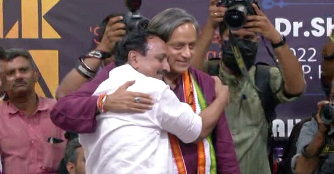 Kozhikode MP MK Raghavan and Thiruvananthapuram MP Shashi Tharoor embrace each other during a seminar organised by Jawahar Youth Foundation in Kozhikode on Sunday, November 20, 2022. Screengrab: Manorama News