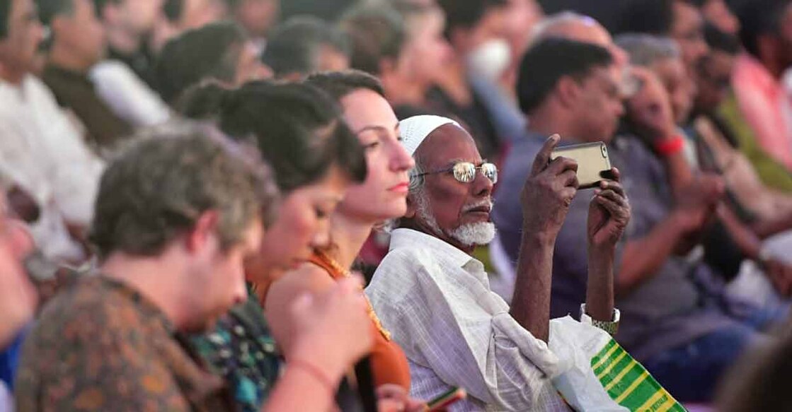 A person in the audience captures the inaugural function of the Kochi-Muziris Biennale at Fort Kochi on Monday. Photo: Manorama