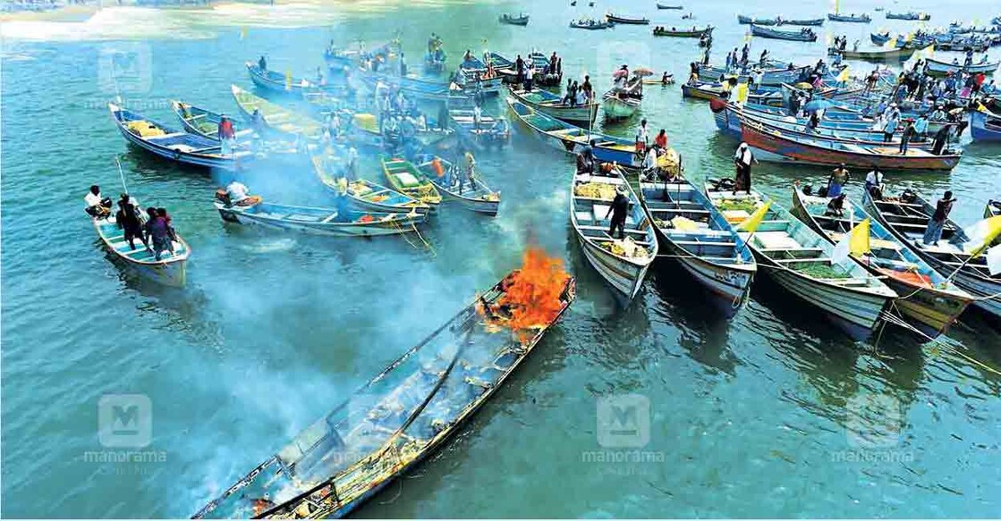 പ്രതിഷേധത്തീക്കടൽ: വിഴിഞ്ഞം തുറമുഖനിർമാണ വിരുദ്ധ സമിതി നടത്തുന്ന സമരത്തിന്റെ നൂറാം ദിനമായ ഇന്നലെ നിർമാണ മേഖലയിൽ മത്സ്യത്തൊഴിലാളികൾ മീൻപിടിത്ത വള്ളം കത്തിച്ചപ്പോൾ. ചിത്രം: മനോജ് ചേമഞ്ചേരി ∙ മനോരമ 
