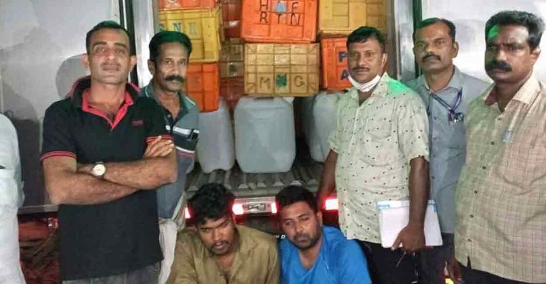 Excise officers pose in front of the van. The accused are seated. 