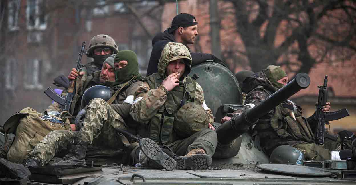UKRAINE-CRISIS-MARIUPOL Service members of pro-Russian troops are seen atop of an armoured vehicle during Ukraine-Russia conflict in the southern port city of Mariupol, Ukraine April 21, 2022. REUTERS/Chingis Kondarov