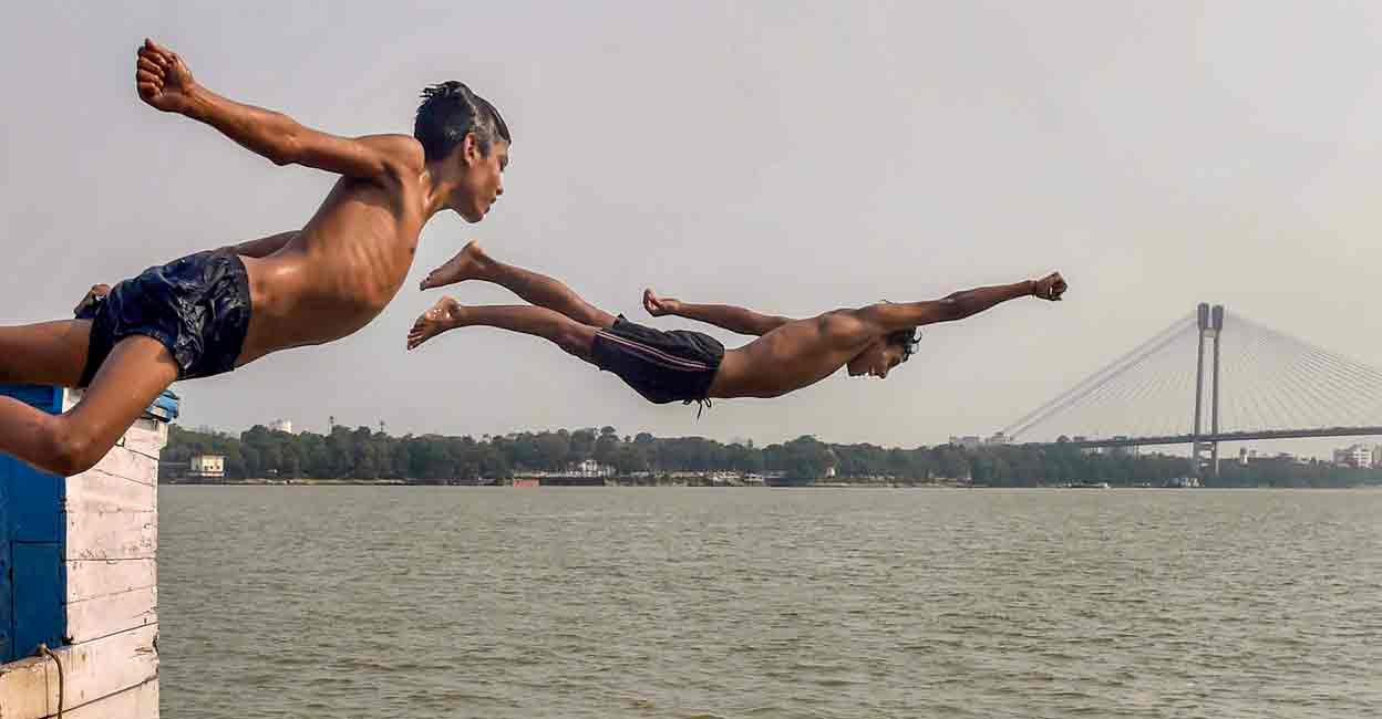 PTI04_27_2022_000151A Boys jump into the Ganga River to beat the heat during a hot summer day, in Kolkata, Wednesday, April 27, 2022. Photo: PTI