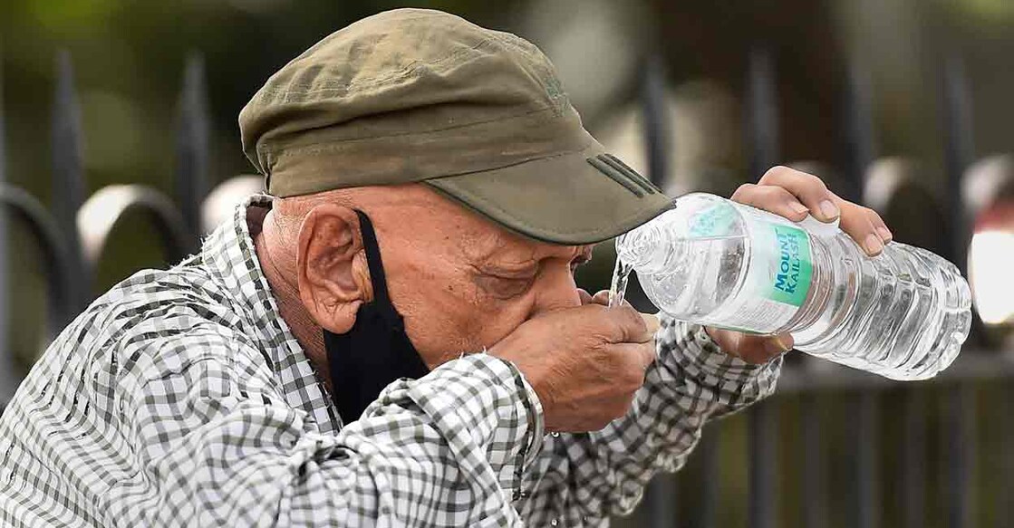 A pedestrian quenches his thirst on a hot summer day, at Cannaught Place in New Delhi, Sunday, April 24, 2022. (PTI Photo/Kamal Singh)