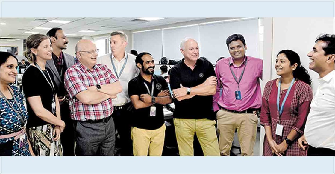 Prevalent AI founders Andy France (4th from left), Paul Stokes (5th from left), Sir Iain Lobban (4th from right), and Arun Raj (right) with HR Director Sara Mottus (2nd from left) and other staff.