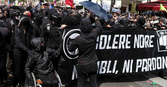 Masked protesters dressed in black (Black Bloc) hold a banner reading 'black anger' as they gather in the district of Montparnasse in Paris on May 1, 2019. Photo: AFP