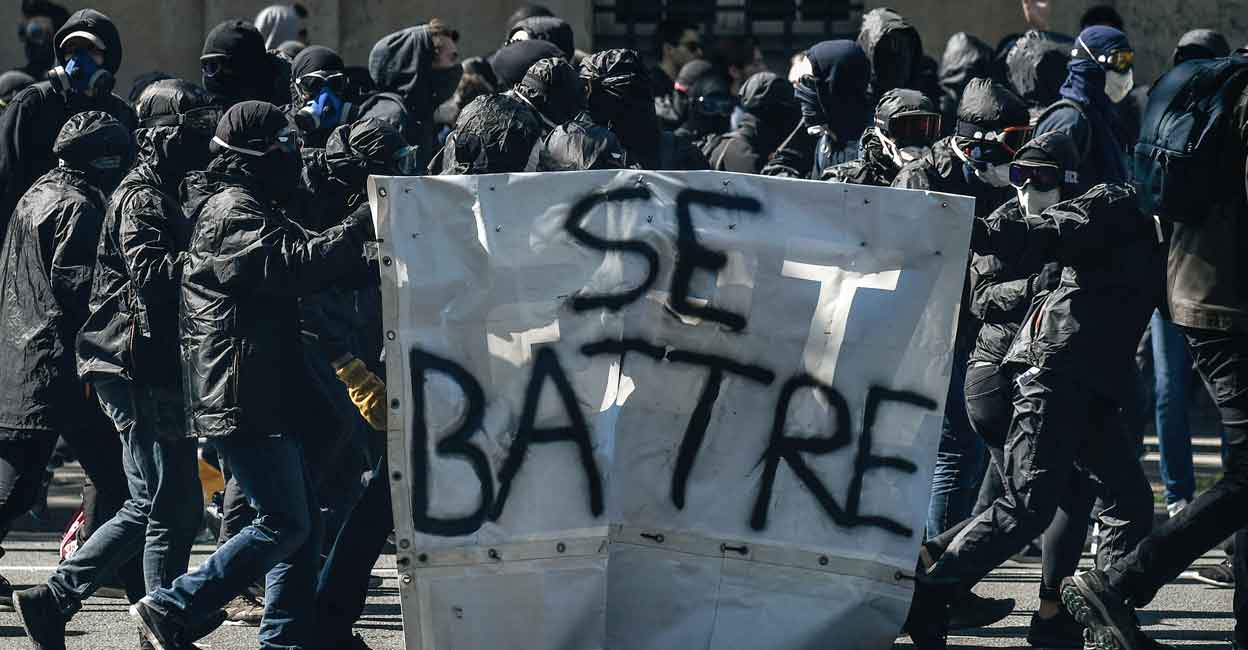 Protesters known as "black bloc" walk with a banner reading in French "to fight" during a demonstration on April 19, 2018 in Paris. Photo: AFP Protesters known as "black bloc" walk with a banner reading in French "to fight" during a demonstration on April 19, 2018 in Paris. Photo: AFP