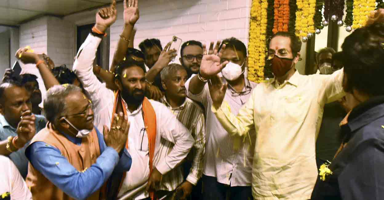 PTI06_22_2022_000269B Maharashtra CM Uddhav Thackeray greets supporters gathered outside his private residence 'Matoshree', after leaving from his official residence 'Varsha', in Mumbai, Wednesday, June 22, 2022. Maharashtra Minister Aaditya Thackeray is also seen. (PTI Photo)