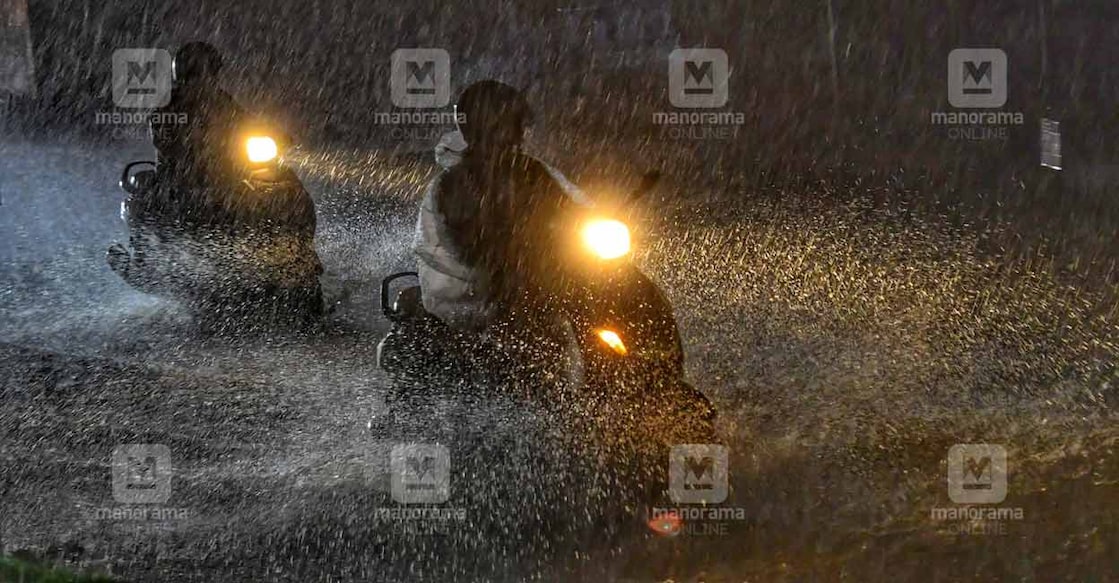 Two-wheelers passing through heavy rain in Kozhikode. PHOTO: Manorama