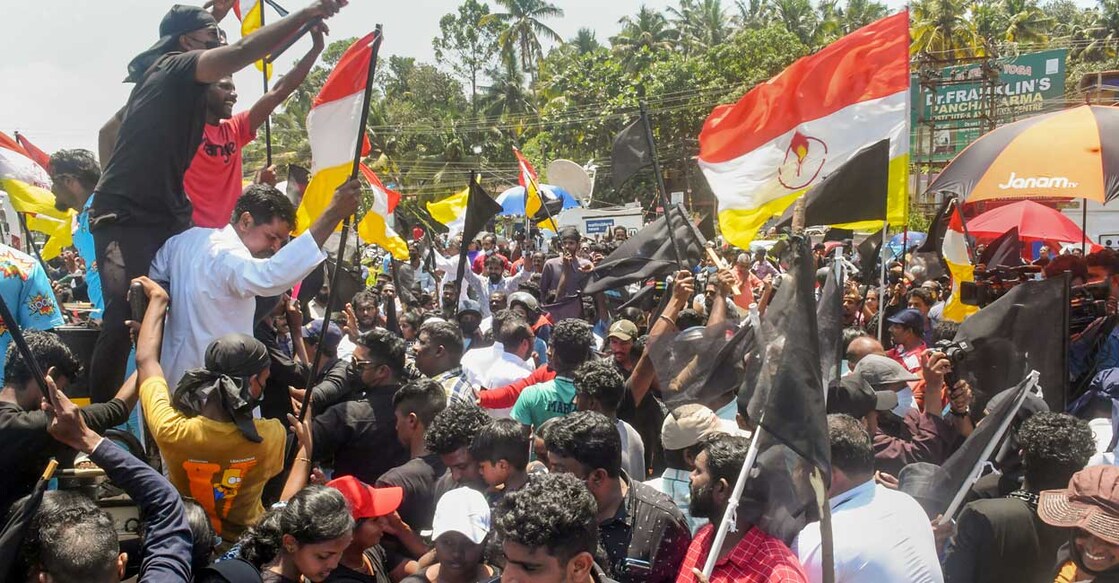 Fishermen and locals holding black flags stage a protest against Adani Groups' port development project at Vizhinjam, outside the main entrance of Adani Port in Thiruvananthapuram, Tuesday, Aug. 16, 2022. Photo: PTI