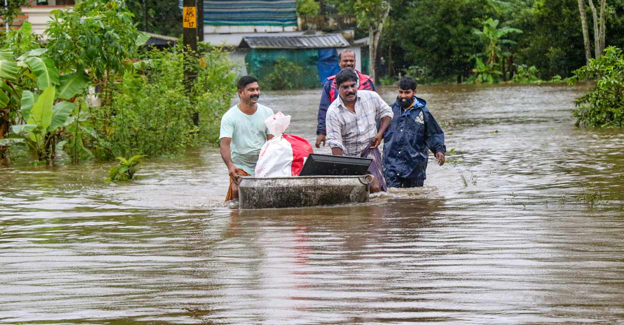 PTI08_04_2022_000302B Local people wade through a flood affected area following heavy monsoon rains, in Thrissur district. File Photo: PTI