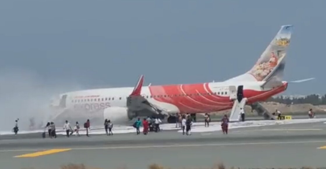 Passengers running from the Air India Express flight after being evacuated. Smoke was seen billowing from the aircraft's wings, on Wednesday. Photo: Twitter/@utkarshs88
