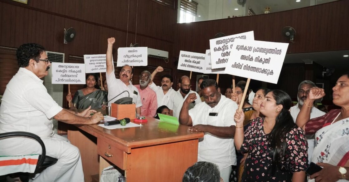 Opposition councillors protest before Mayor MK Varghese during a council meeting in the Thrissur Corporation on Thursday. Photo: Special arrangement