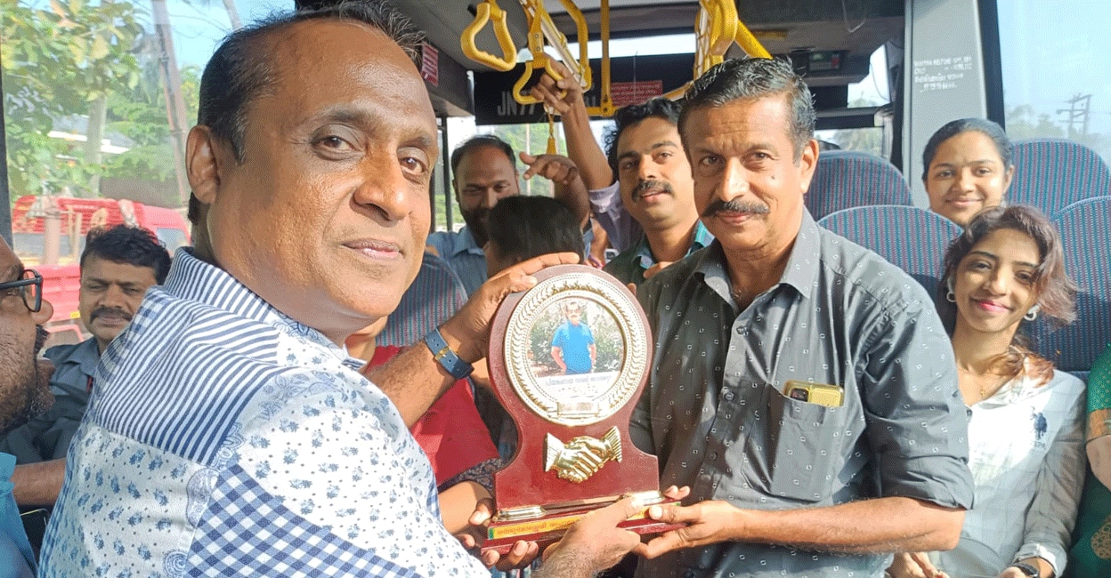 manoj-ksrtc-driver-send-off Regular passengers of Alappuzha-Nedumbassery low-floor AC bus presenting a memento to CR Manoj (right). Photo: Special arrangement