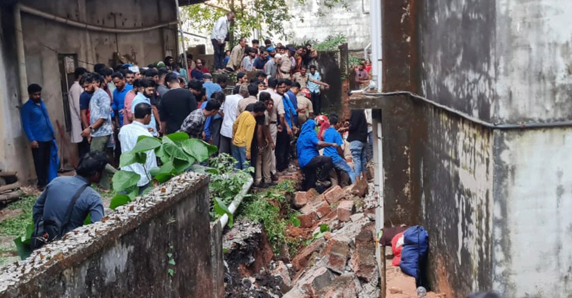Headload workers and police remove the debris of a wall to pull out two workers trapped underneath at Market road in Kasaragod town on Tuesday. Photo: Special arrangement