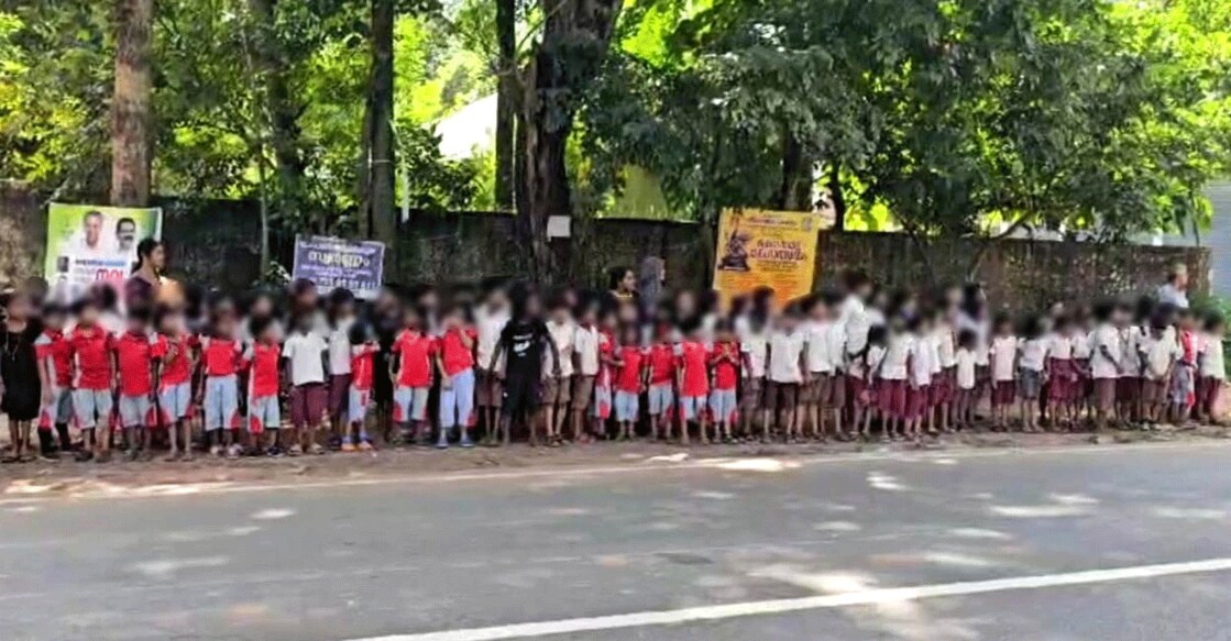 Students of Thuyyam School, Edappal wait on the roadside to greet the Nava Kerala Sadas bus Monday afternoon. Photo: Special arrangement