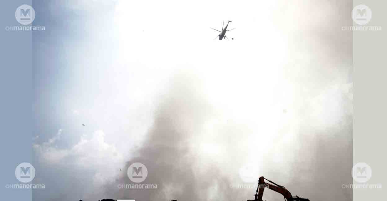 A chopper of the Indian Navy tries to extinguish the fire at Brahmapuram waste plant. Photo: I & PRD
