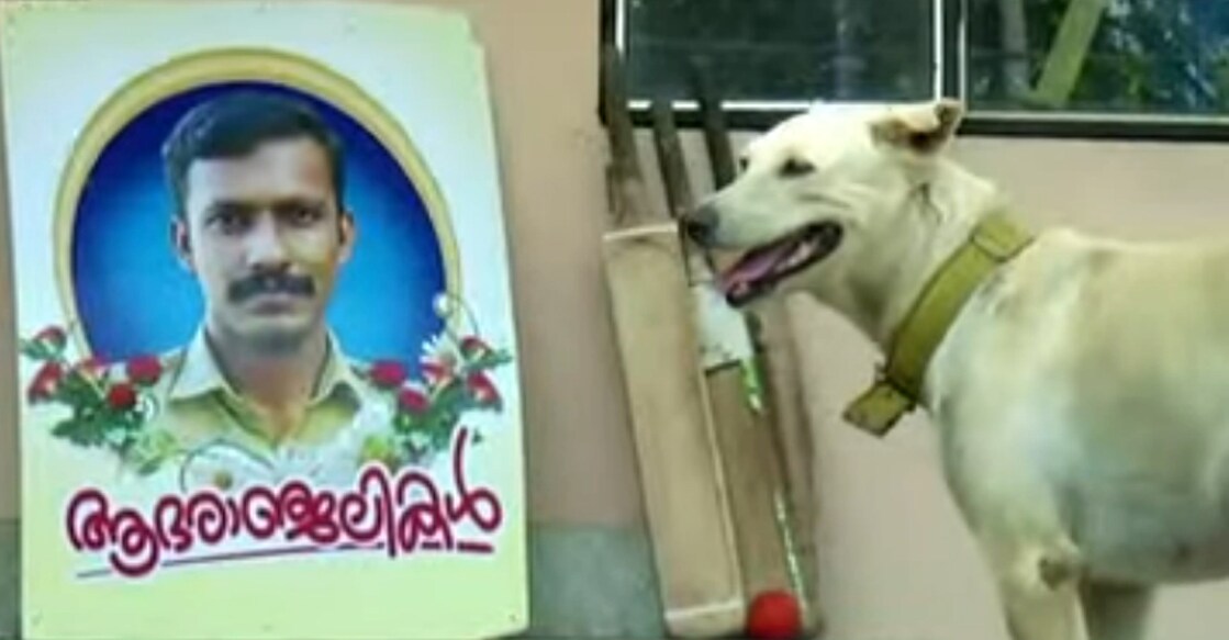 Susi stands next to a flex board, a tribute to JS Ranjith, at the Fire and Rescue Station at Chacka in Thiruvananthapuram. Photo: Screengrab/Manorama News