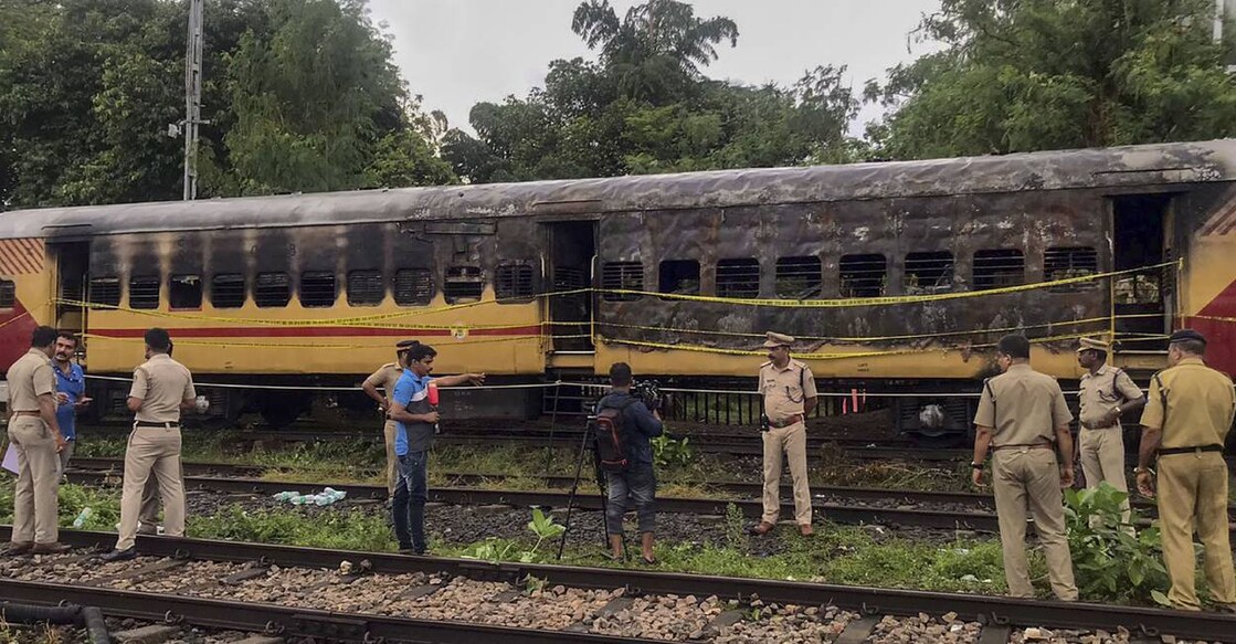 Police personnel inspect the Alappuzha-Kannur Executive Express train which caught fire, at a railway station in Kannur. Photo: PTI