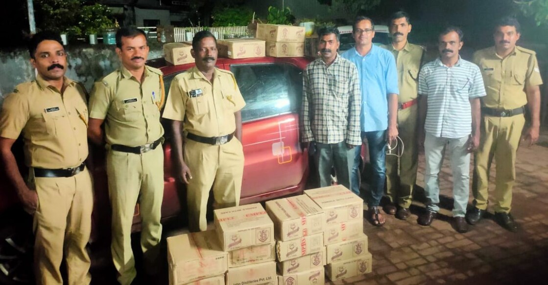 Excise officials pose with the vehicles and liquor seized at Kumaramangala in Bela village of Kasaragod district Wednesday night. Photo: Special Arrangement