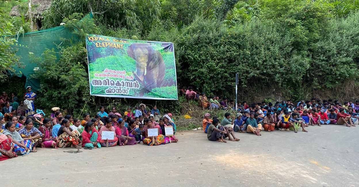 chinnakanal Tribals from five settlement colonies in Chinnakanal holding a sit-in protest by the roadside on Suryanelli-Sinkukandam road on Tuesday demanding to bring back ‘Arikomban’ from forests of Tamil Nadu. Photo: Special Arrangement