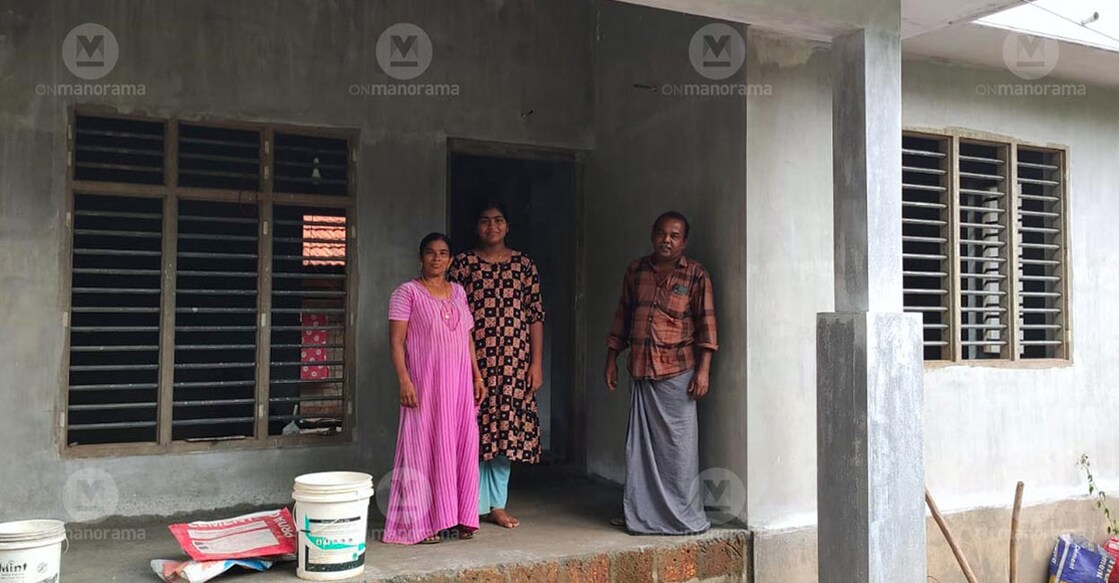 Devika and her foster parents in front of their new house being constructed at Velimanam in Kannur's Aralam grama panchayat. Photo: George Poikayil/ Manorama


