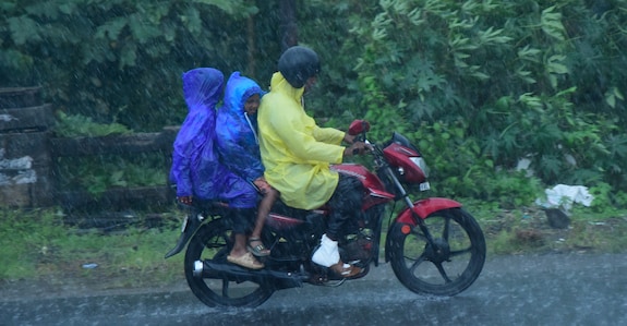 kerala-rain-bike-riders Children ride pillion on a bike in Kozhikode on Tuesday. Photo: Manorama
