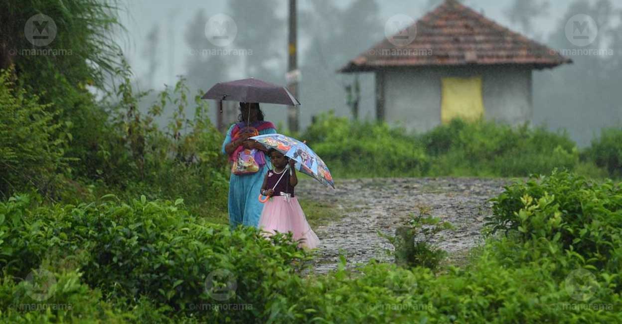 A mother and daughter brave the rainy weather in Wayanad. Photo: Manorama
