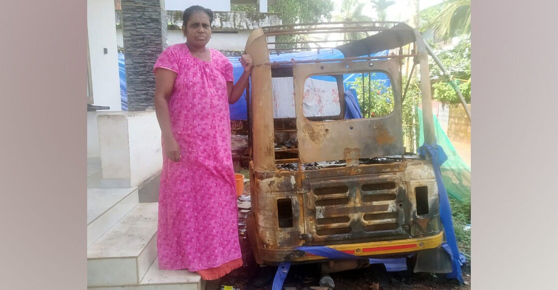 Chithralekha stands next to her charred auto in front of her house. Photo: Special arrangement